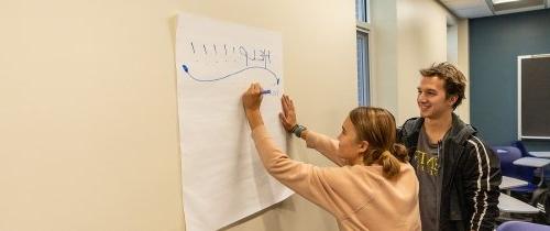 Centre students writing help on a poster